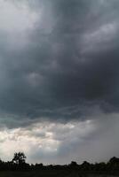 Black clouds in the sky in the rainy season are the formations of a rain storm in the evening. The background of the sky full of black dark rain clouds photo