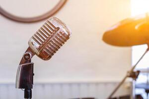 A silver vintage-style microphone is housed in the practice room to prepare singers to practice vocals through a quality microphone and record vocals to keep listening to improve their singing. photo
