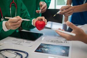 concept of medical team meeting to discuss about treating heart disease with surgery and preventing recurrence of heart disease later. medical team meeting about cardiology to treat patients. photo