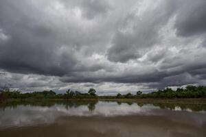 The rain clouds that are forming above the sky are rain clouds of the storms that are bringing moisture into the seasonal areas. The background of the sky is full of black clouds from thunderstorm photo
