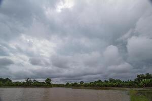 The rain clouds that are forming above the fields are rain clouds caused by storms that are resting moisture into the seasonal areas. The sky background is full of black clouds from thunderstorm. photo