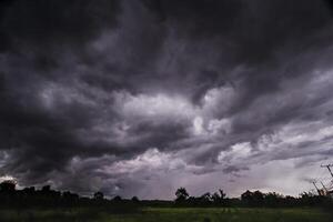 The rain clouds that are forming above the sky are rain clouds of the storms that are bringing moisture into the seasonal areas. The background of the sky is full of black clouds from thunderstorm photo