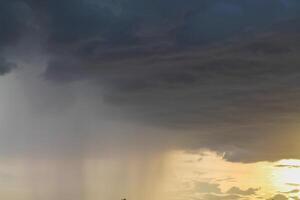 Black clouds in the sky in the rainy season are the formations of a rain storm in the evening. The background of the sky full of black dark rain clouds photo