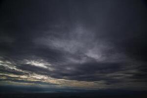 The rain clouds that are forming above the sky are rain clouds of the storms that are bringing moisture into the seasonal areas. The background of the sky is full of black clouds from thunderstorm photo