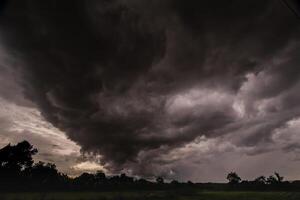 The rain clouds that are forming above the sky are rain clouds of the storms that are bringing moisture into the seasonal areas. The background of the sky is full of black clouds from thunderstorm photo