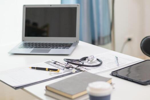 stethoscope is placed on work desk in doctor office After examining patient stethoscope is placed on the work desk to examine additional information from the computer that has compiled the results. photo