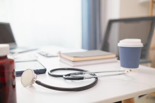 stethoscope is placed on work desk in doctor office After examining patient stethoscope is placed on the work desk to examine additional information from the computer that has compiled the results. photo