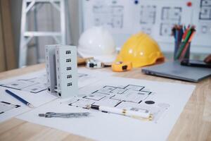 A team of engineers and architects discuss house plan design and estimate construction prices to suit the construction budget. Checking blueprints and documents with a team of engineers and architects photo