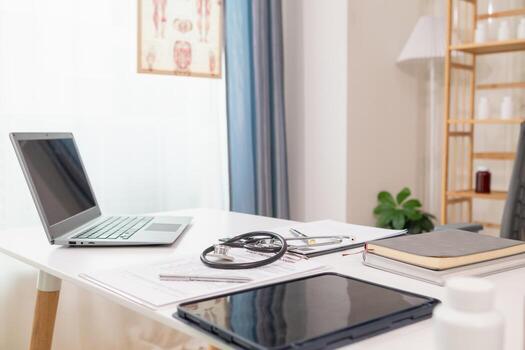 stethoscope is placed on work desk in doctor office After examining patient stethoscope is placed on the work desk to examine additional information from the computer that has compiled the results. photo