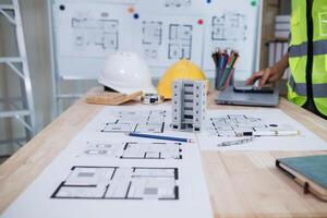 A team of engineers and architects discuss house plan design and estimate construction prices to suit the construction budget. Checking blueprints and documents with a team of engineers and architects photo
