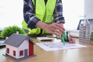 A team of engineers and architects discuss house plan design and estimate construction prices to suit the construction budget. Checking blueprints and documents with a team of engineers and architects photo