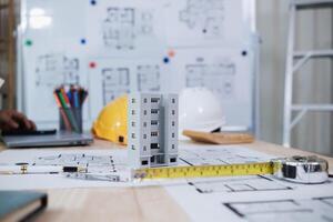 A team of engineers and architects discuss house plan design and estimate construction prices to suit the construction budget. Checking blueprints and documents with a team of engineers and architects photo