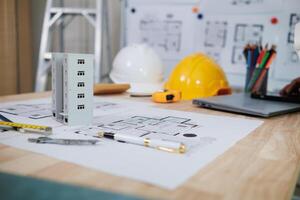 A team of engineers and architects discuss house plan design and estimate construction prices to suit the construction budget. Checking blueprints and documents with a team of engineers and architects photo