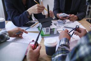team of engineers and architects discuss house plan design and estimate construction prices to suit the construction budget. Checking blueprints and documents with a team of engineers and architects photo
