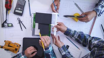 team of engineers and architects discuss house plan design and estimate construction prices to suit the construction budget. Checking blueprints and documents with a team of engineers and architects photo