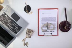 Handcuffs and legal documents were placed on table inside lawyer office after court decision was announced. legal counsel On desk documents and handcuffs were placed after court fought and won case. photo