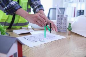 A team of engineers and architects discuss house plan design and estimate construction prices to suit the construction budget. Checking blueprints and documents with a team of engineers and architects photo