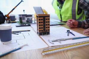 A team of engineers and architects discuss house plan design and estimate construction prices to suit the construction budget. Checking blueprints and documents with a team of engineers and architects photo