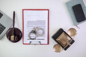Handcuffs and legal documents were placed on table inside lawyer office after court decision was announced. legal counsel On desk documents and handcuffs were placed after court fought and won case. photo