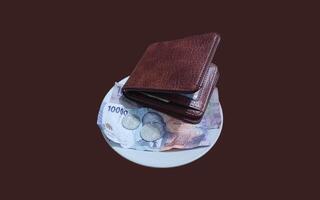 Ceramic cup with wallet and Indonesian rupiah banknotes on brown background. photo