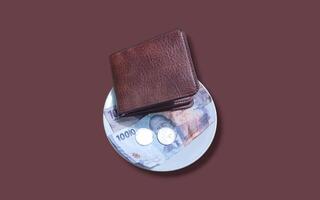 Ceramic cup with wallet and Indonesian rupiah banknotes on brown background. photo