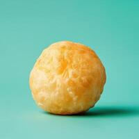 Scrumptious Brazilian Cheese Bread Ball Isolated on a Solid Mint Green Background photo