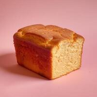 Moist and fluffy loaf cake with a golden crust on a pink background photo