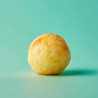 Single golden brown potato croquette on a pale green background photo