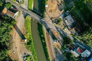 Sleman, Yogyakarta, Indonesia, 2024 - Toll road construction project over the Mataram ditch. A toll bridge is being built over the water flow so as not to displace rice fields and settlements photo