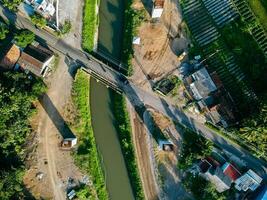 Sleman, Yogyakarta, Indonesia, 2024 - Toll road construction project over the Mataram ditch. A toll bridge is being built over the water flow so as not to displace rice fields and settlements photo