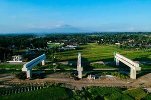 Sleman, Yogyakarta, Indonesia, 2024 - Toll road construction project over the Mataram ditch. A toll bridge is being built over the water flow so as not to displace rice fields and settlements photo