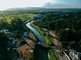 Sleman, Yogyakarta, Indonesia, 2024 - Toll road construction project over the Mataram ditch. A toll bridge is being built over the water flow so as not to displace rice fields and settlements photo