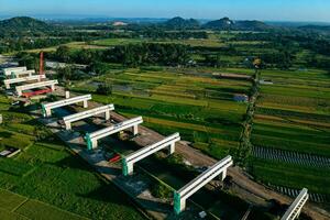 Sleman, Yogyakarta, Indonesia, 2024 - Toll road construction project over the Mataram ditch. A toll bridge is being built over the water flow so as not to displace rice fields and settlements photo
