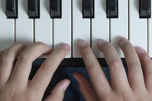 Piano chords and scales. Music exercises. Two hands playing. Close-up photo