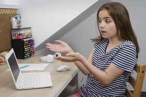 A teenage girl points to a broken computer. Homework not completed. Computer problem photo