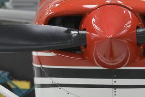 Front part of a red aircraft with a propeller. Screws, texture, surface, close-up photo