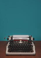 Typewriter 70s with red printed ribbon on the table and blue background photo
