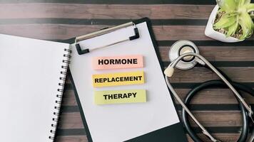 Concept of Hormone Replacement Therapy write on sticky notes isolated on Wooden Table. photo