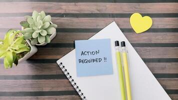 Concept of Action Required write on sticky notes isolated on Wooden Table. photo