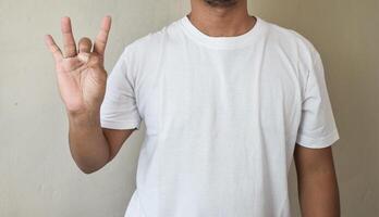 A man hands raising and pointing up with fingers number eight while standing over photo