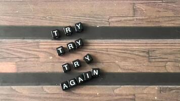 Concept of Try Try Try Again written on wooden blocks. Cross processed image on Wooden Background photo