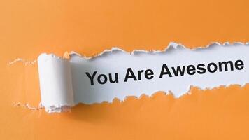 Concept of You Are Awesome Text written in torn paper. photo