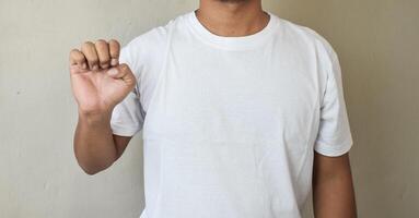 Cropped shot of man raising his hand and pointing letter e using sign language photo