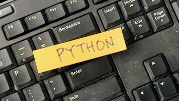 Concept of Python write on sticky notes isolated on Wooden Table. photo