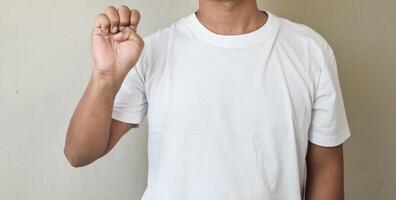Cropped shot of man raising his hand and pointing letter e using sign language photo