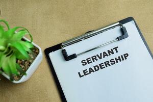 Concept of Servant Leadership write on paperwork isolated on wooden background. photo