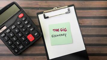 Concept of The Gig Economy write on sticky notes isolated on Wooden Table. photo