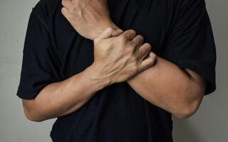 Man's arm touches a painful wrist cause by work photo