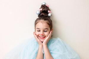 Cheerful portrait of a little girl with styling in the form of a Christmas tree photo