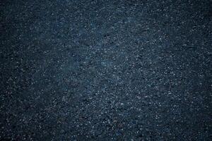 Top view on a dark gray asphalt surface as background, texture photo